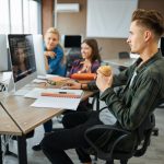 Young IT specialists works on computers in office